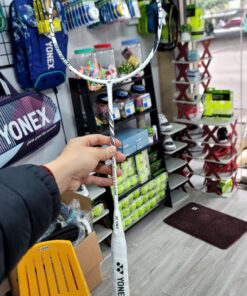 Hand holding Yonex badminton racket