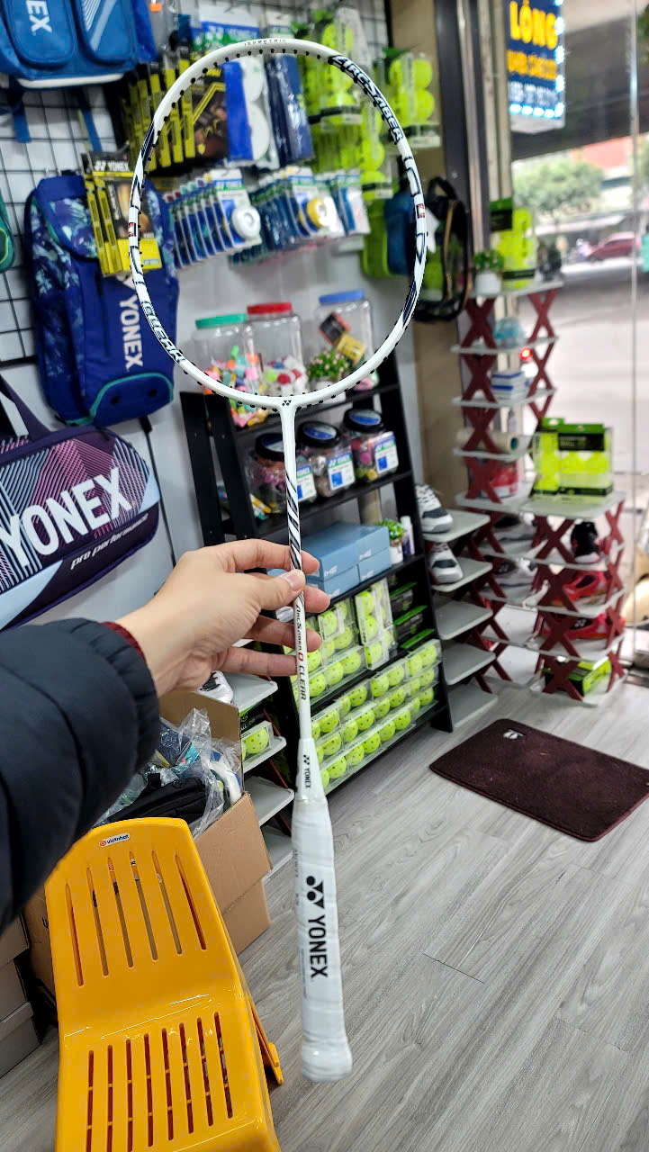 Hand holding Yonex badminton racket